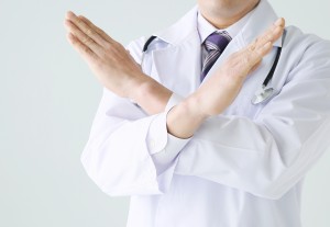 両手でバツのジェスチャーをする医師