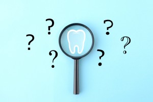 虫眼鏡と歯のイラストとクエスチョンマークの画像