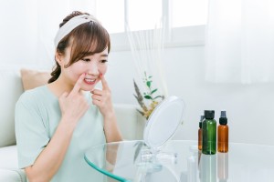 鏡を見ながら口腔筋トレーニングする女性