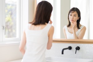 鏡で自分の顔を確認する女性