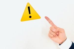 注意マークを指差す手の画像