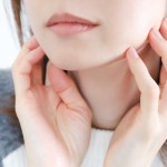 両手で自身の輪郭を触る女性
