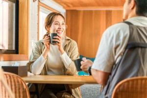 コップを持ちながら話す女