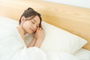 ベッドで寝る女性