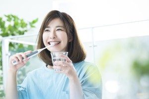 電動歯ブラシを使う女