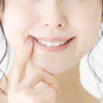 歯を見せて笑う女性の口元の画像