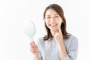 手に鏡を持った笑顔の女性