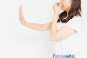 鼻を摘んで否定する女