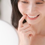手鏡で歯をチェックする女性