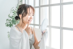 鏡で歯を確認する女性