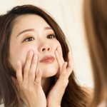 鏡で顔を見る女性のイメージ