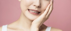 頬を押さえる女性